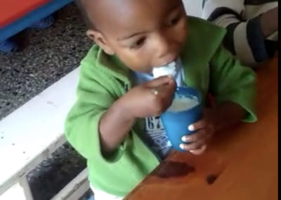 Enfant à table qui mange un yaourt